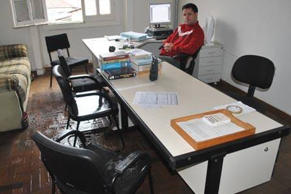 Funcionários trabalham com máscaras e debaixo de chuva em delegacia da PC