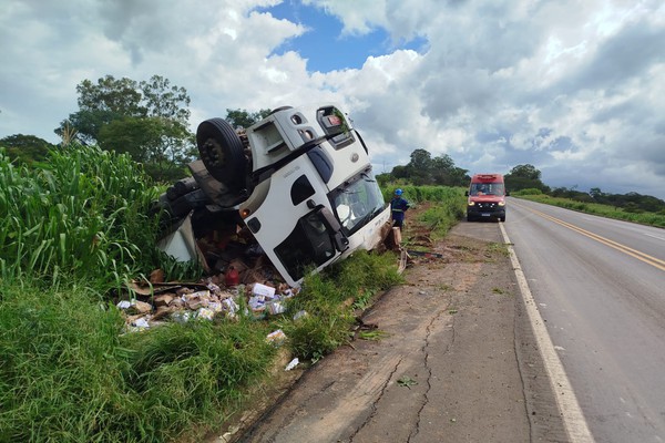 Motorista sai ileso após caminhão carregado com paçoca sair da pista e capotar na BR365